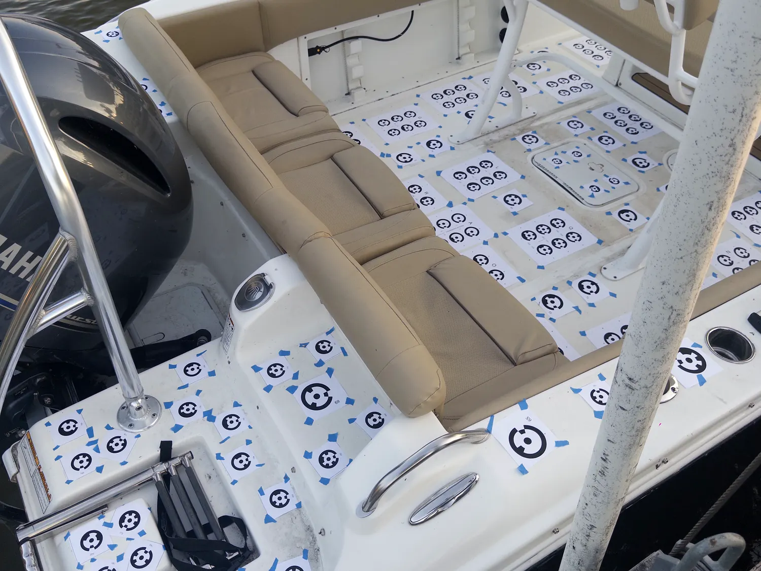 Scan targets taped in a grid across the deck and gunwales of a centre console boat on its lift